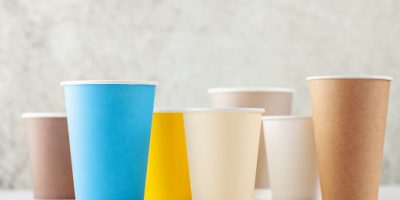 Set of colorful paper cups for coffee or tea on a gray background.  Mock up